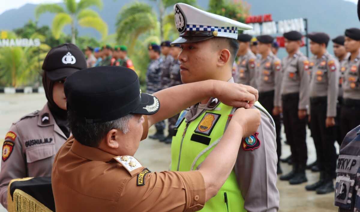 apel operasi Lilin Seligi anambas Wakil Bupati Kepulauan Anambas Wan Zuhendra menyematkan pita kepada personel yang terlibat dalam Operasi Lilin Seligi 2022 dalam apel gelar pasukan di Mapolres Anambas, Kamis (22/12/2022). (Jurnal/ist)