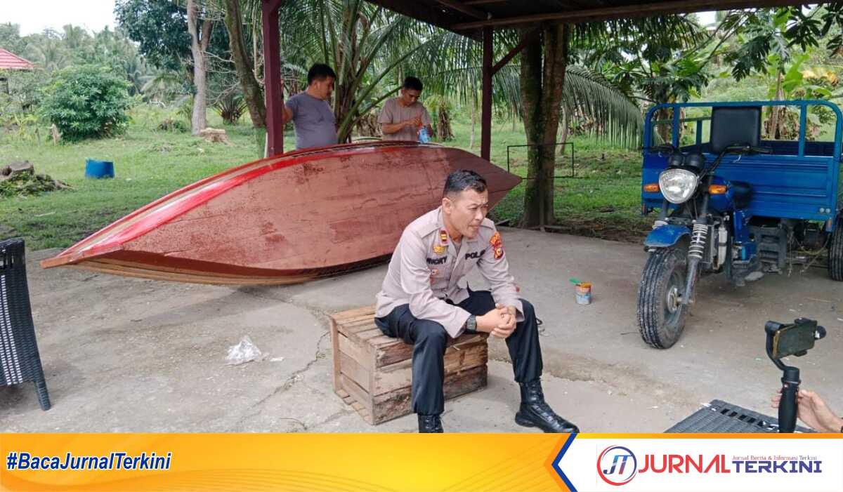 Kapolsek Tembilahan Hulu Iptu Ricky Marzuki menyiapkan bantuan sampan untuk keluarga Talip. (JurnalTerkini.id/Abdullah)