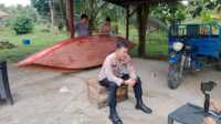 Kapolsek Tembilahan Hulu Iptu Ricky Marzuki menyiapkan bantuan sampan untuk keluarga Talip. (JurnalTerkini.id/Abdullah)