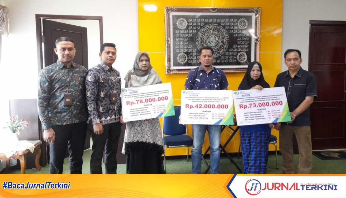 Dua perwakilan dari BPJS Ketenagakerjaan Cabang Indragiri Hilir (kiri) dan Ketua DPRD Inhil Ferryandi (kanan) bersama tiga ahli waris berfoto bersama usai penyerahan santunan di Tembilahan, Kamis (26/1/2023). (JurnalTerkini.id/abdullah)