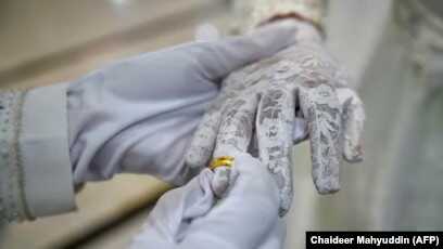 Seorang pengantin pria memasang cincin di jari istrinya saat upacara pernikahan di sebuah masjid di Banda Aceh pada 3 Juni 2020. (Foto: AFP/Chaideer Mahyuddin)