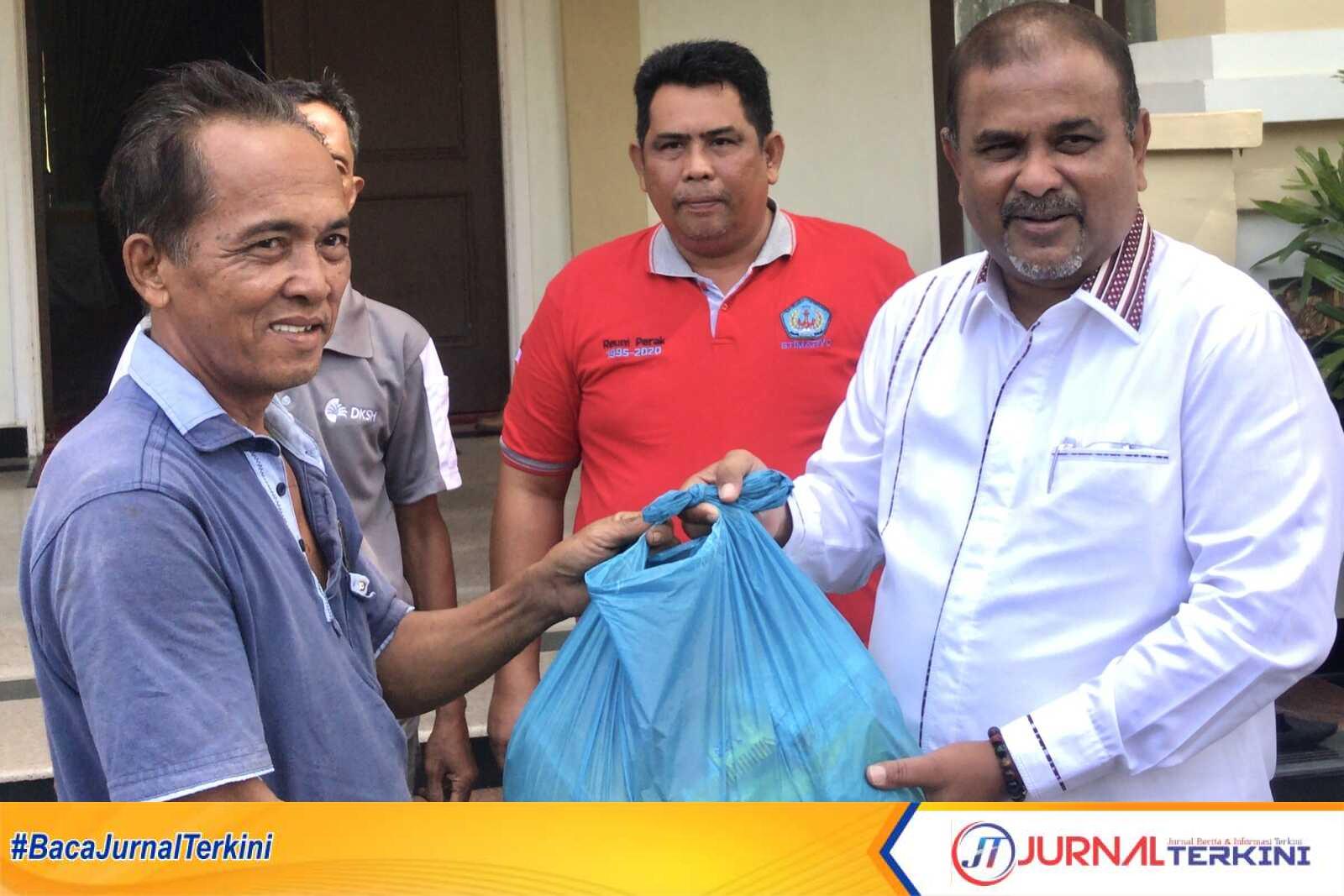 Bupati Karimun Aunur Rafiq menyerahkan bantuan paket sembako kepada seorang tenaga kerja bongkar muat di Pelabuhan Taman Bunga, Tanjung Balai Karimun, Jumat (10/2/2023). (Dok Diskominfo Karimun)