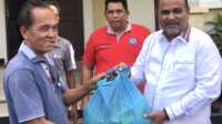 Bupati Karimun Aunur Rafiq menyerahkan bantuan paket sembako kepada seorang tenaga kerja bongkar muat di Pelabuhan Taman Bunga, Tanjung Balai Karimun, Jumat (10/2/2023). (Dok Diskominfo Karimun)