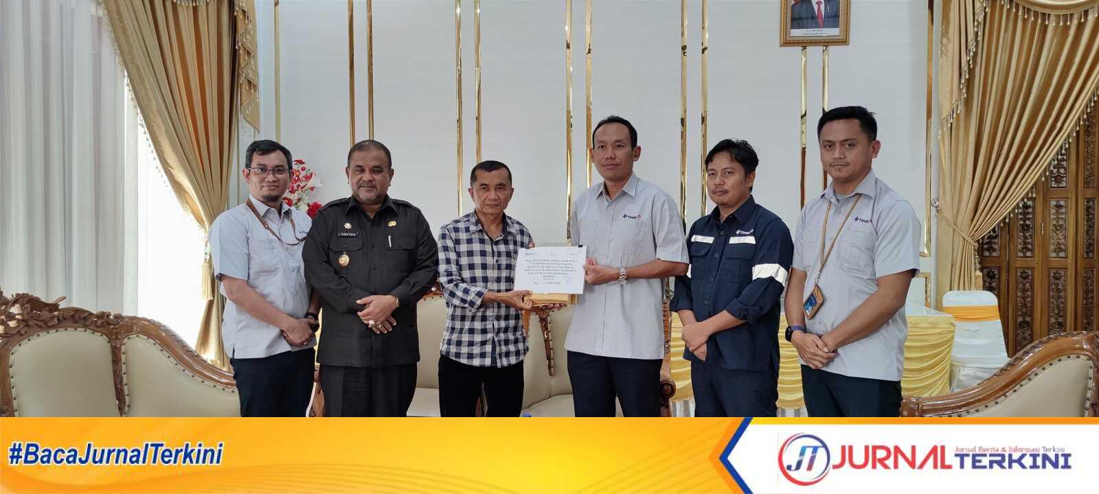 Manajemen Ot Timah Tbk menyerahkan bantuan kepada Ketua KONI Karimun Jhon Abrison (3 kiri) disaksikan Bupati Karimun Aunur Rafiq (2 kiri) di rumah dinas Bupati, Senin (6/2/2023). (JurnalTerkini.id/yogi)