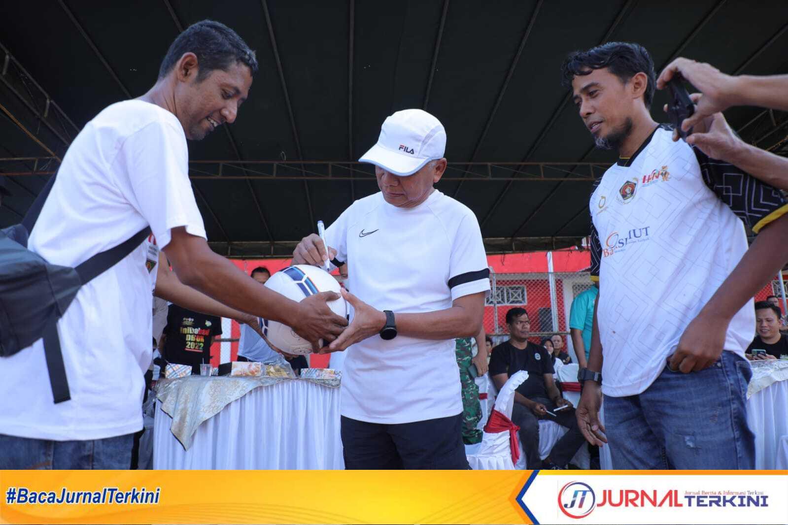 Bupati Asahan H Surya BSc menandatangani bola tanda dimulai turnamen sepak bola Old Crack PWI Asahan di stadional olahraga Asahan, Jumat (24/2/2023). (JurnalTerkini.id/Rizki)