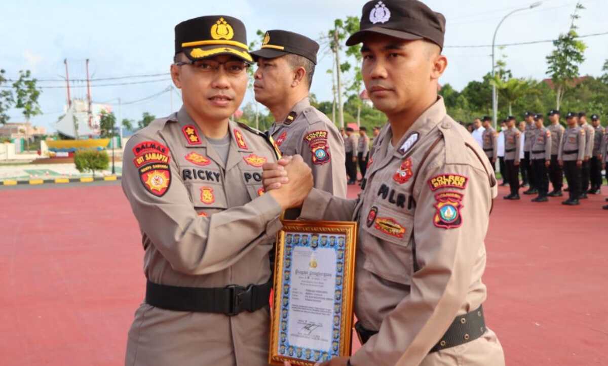 Kapolres Bintan AKBP Riky Iswoyo memberi penghargaan kepada personel berprestasi dalam upacara di Mapolres Bintan, Rabu (8/2/2023). (Dok. Humas Polres Bintan)