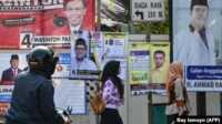 kampanye Pemilu 2019 Pejalan kaki melewati spanduk kampanye Pemilu 2019 di Jakarta.(Foto: AFP/Bay Ismoyo)
