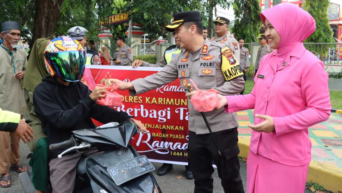 Kapolres Karimun AKBP Ryky W Muharam bersama Ketua Bhayangkari Cabang Karimun Ny Meity Ryky bagi-bagi takjil kepada pengendara yang melintas di depan Mapolres Karimun, Senin (27/3/2023). (Dok Humas Polres Karimun)