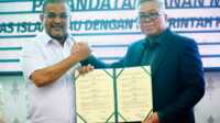 Bupati Karimun Aunur Rafiq dan Wakil Rektor I UIR Dr. H. Syafhendry, M.Si memperlihatkan naskah MoU usai penandatanganan naskah tersebut di ruang rapat lantai II Rektorat UIR Pekanbaru, Kamis (2/3/2023). (Foto: istimewa)