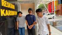 IMG-20230328-WA0003 JA, tersangka penjual chip higgs domino digiring penyidik di Mapolres Karimun, Selasa (28/3/2023). (Dok Humas Polres Karimun)
