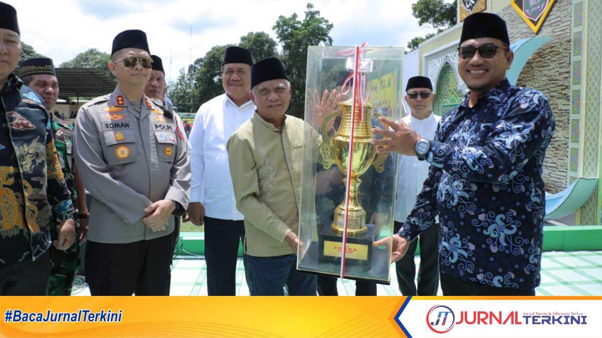 Bupati Asahan H Surya BSc menyerahkan Piala kepada Kecamatan Air Joman yang meraih juara umum MTQN ke-54 Asahan, Minggu (5/3/2023). (JurnalTerkini.id/rizki)