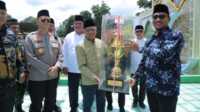 Bupati Asahan H Surya BSc menyerahkan Piala kepada Kecamatan Air Joman yang meraih juara umum MTQN ke-54 Asahan, Minggu (5/3/2023). (JurnalTerkini.id/rizki)