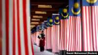aset Malaysia Sultan Sulu Seorang mahasiswa Universitas Nasional Malaysia berjalan melewati jajaran bendera nasional Malaysia di luar Kuala Lumpur 22 Agustus 2007. (Foto: Reuters/Bazuki Muhammad)