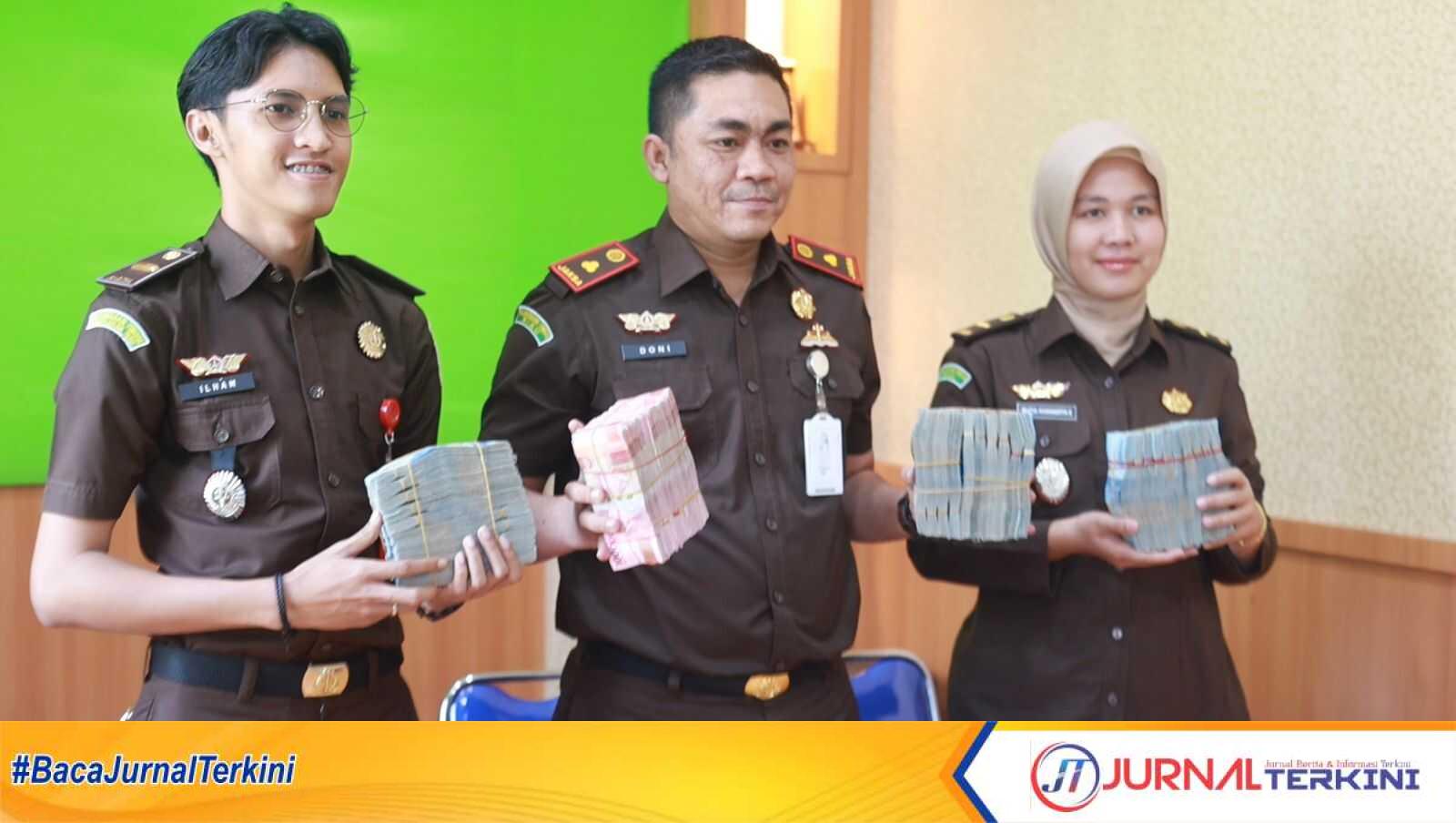 Kacabjari Karimun di Tanjungbatu Doni Saputra (tengah) beserta jajaran menunjukkan uang yang disita dari PKBM Bakti Negeri di kantornya, Selasa (4/4/ 2023). (foto istimewa)