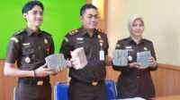 Kacabjari Karimun di Tanjungbatu Doni Saputra (tengah) beserta jajaran menunjukkan uang yang disita dari PKBM Bakti Negeri di kantornya, Selasa (4/4/ 2023). (foto istimewa)