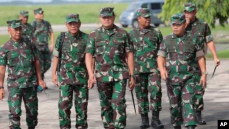 Panglima TNI Laksamana TNI Yudo Margono (tengah), berjalan bersama stafnya di Pangkalan Udara Juanda, Surabaya, Jawa Timur, Selasa, 18 April 2023. (AP/Trisnadi)