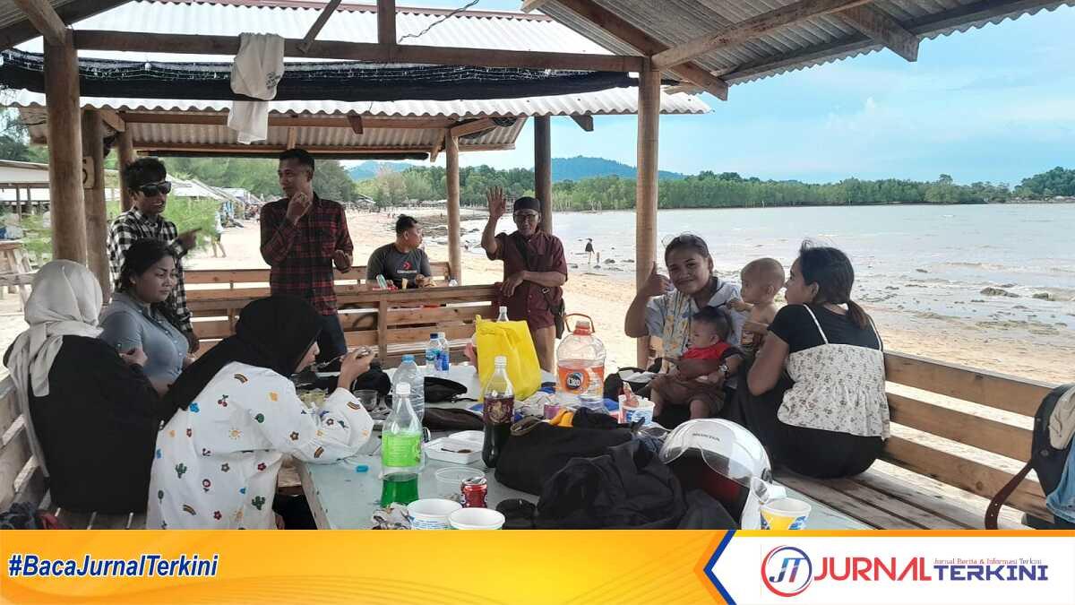 Pengunjung Pantai Ketam menikmati kuliner di pondok yang berjejer di sepanjang pantai, Selasa (25/4/2023). (JurnalTerkini.id/Rusdi)