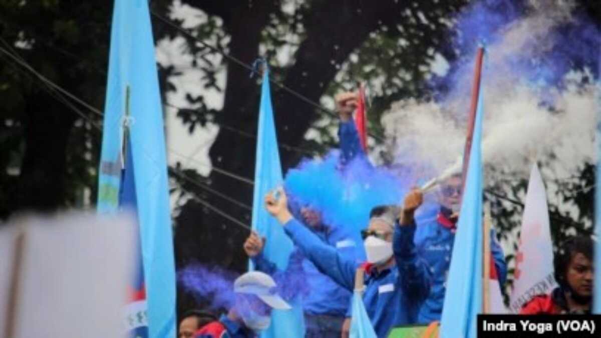 Para buruh merayakan "kemenangan" mereka setelah hakim di Mahkamah Konstitusi membacakan putusan uji materi UU Cipta Kerja agar ditinjau ulang oleh DPR dan Pemerintah Indonesia, Jakarta, 25 November 2021. (Foto: Indra Yoga/VOA)