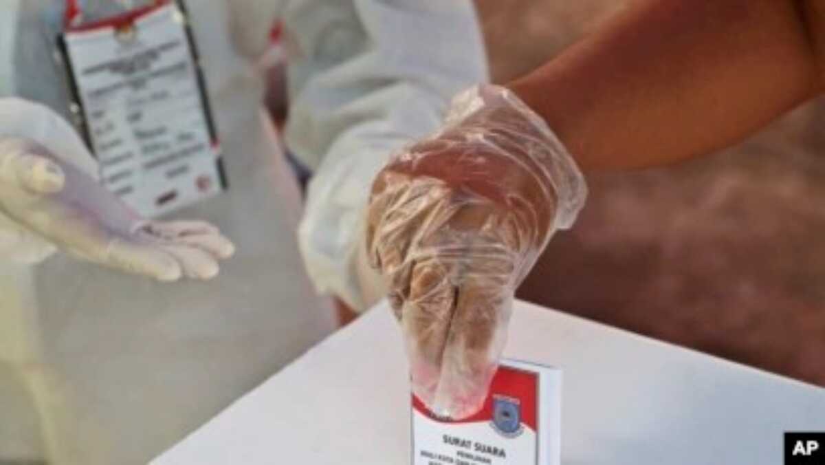 komnas nak hak pilih kelompok rentan Seorang perempuan yang mengenakan sarung tangan plastik sebagai antisipasi wabah virus corona memberikan suaranya saat pemilihan kepala daerah di sebuah TPS di Tangerang, Rabu, 9 Desember 2020. (Foto: AP)
