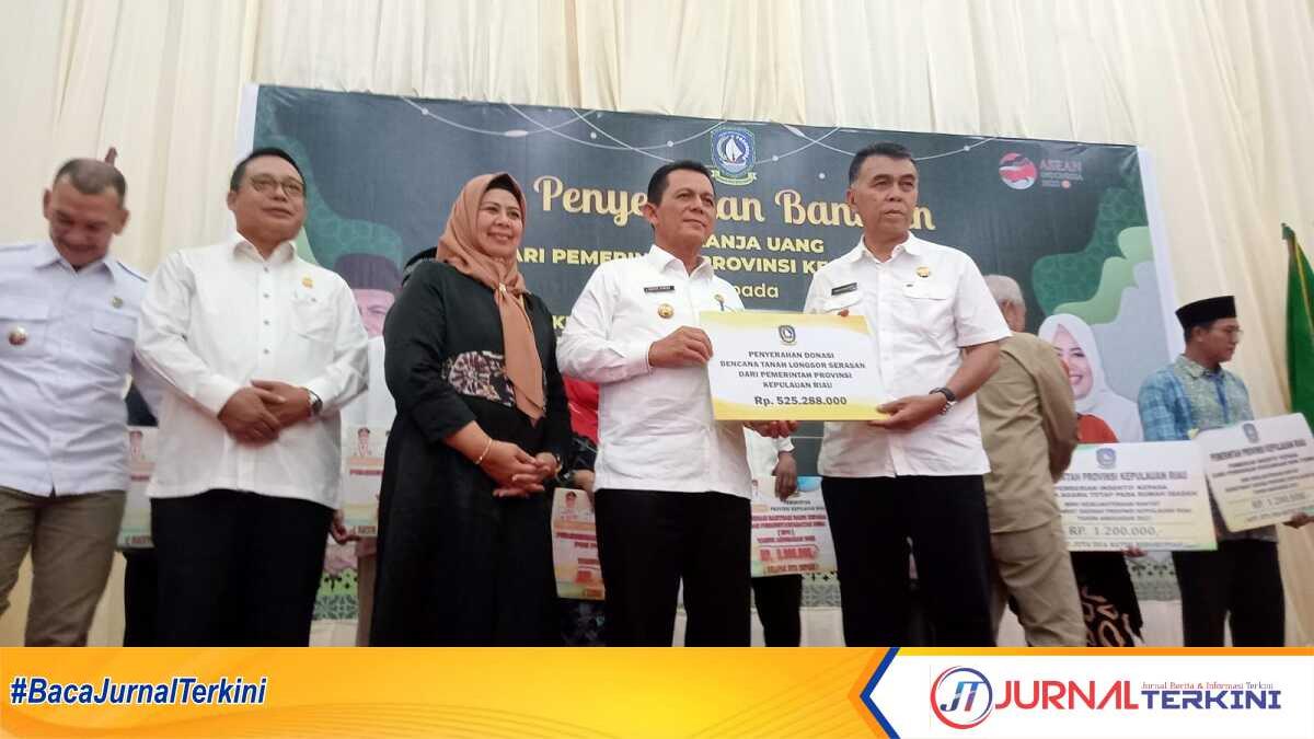 Ansar Ahmad secara simbolis menyerahkan bantuan korban tanah longsor serasan kepada Wan Siswandi di Gedung Sri Serindit, Ranai, Rabu (5/4/2023). (foto: jr ronald)