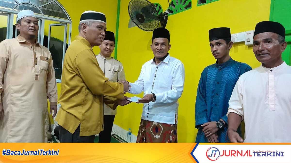 Asisten Tata Pemerintahan Sekretariat Daerah Kabupaten Karimun sularno menyerahkan santunan dalam safari Ramadhan di Masjid Al Hidaya, Desa Sei Asam, Kecamatan Belat, Rabu (12/4/2023) malam. (JurnalTerkini.id/rusdianto)
