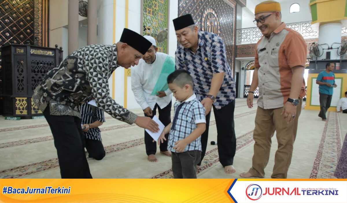 Bupati Asahan Surya bersama Badan Kesejahteraan Masjid Agung H Achmad Bakrie menyerahkan santunan untuk anak yatim dan kaum dhuafa, Jumat (14/4/2023). (JurnalTerkini.id/Rizki)