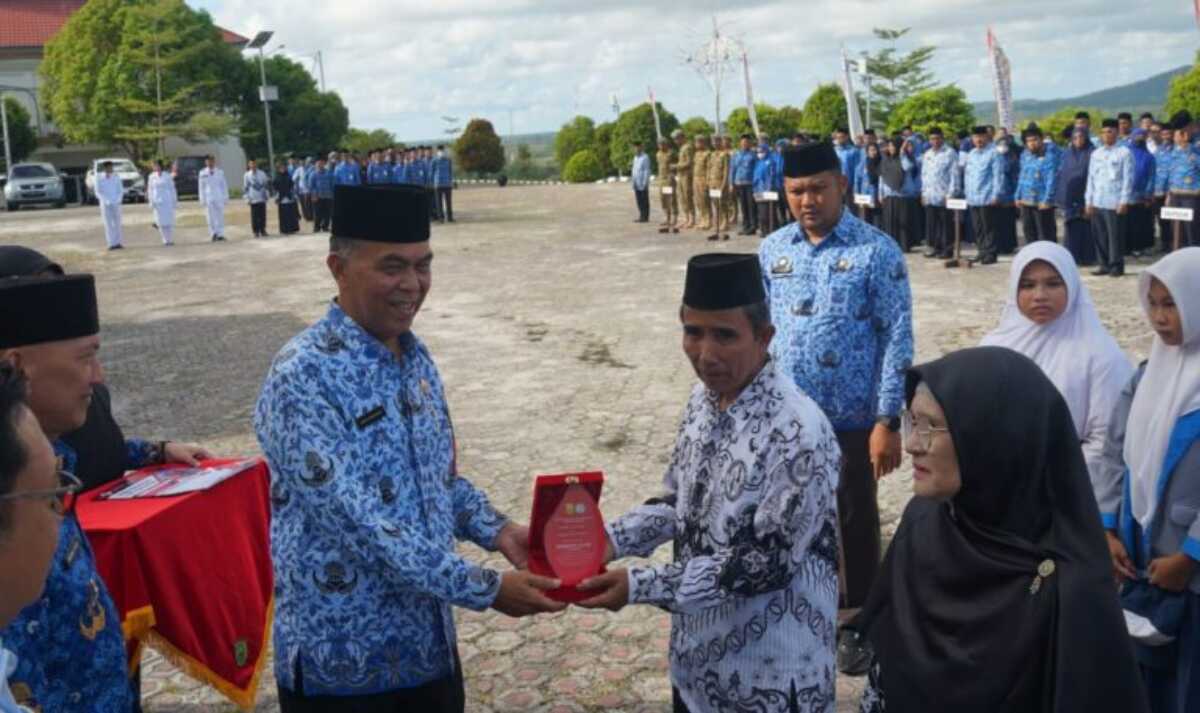 Bupati Natuna Wan Siswandi memberikan Piagam Penghargaan kepada guru dan tenaga kependidikan atas kinerja, dedikasi dan loyalitas kepada dunia pendidikan usai upacara Hardiknas di Kantor Bupati Natuna, Selasa (2/5/2023). (foto Diskominfo Natuna)