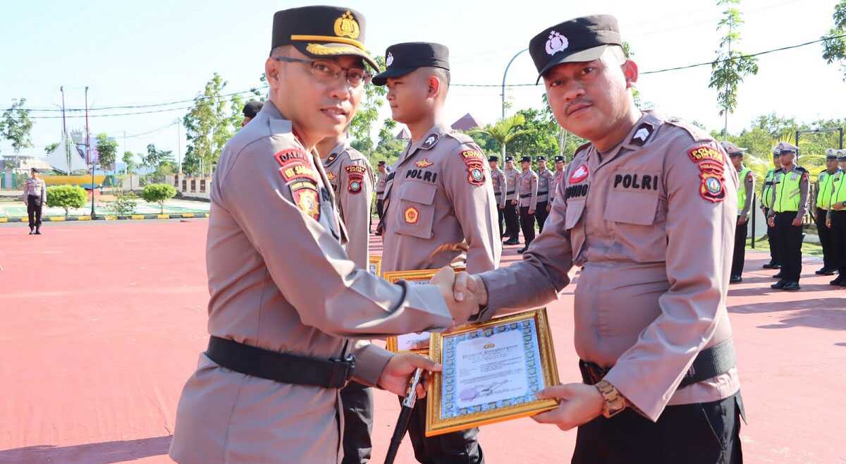 Kapolres Bintan AKBP Riky Iswoyo memberikan penghargaan kepada personel berprestasi dan berdedikasi usai upacara peringatan Hari Kebangkitan Nasional ke-115 di Mapolres Bintan, Senin (22/5/2023). (Dok. Humas Polres Bintan)