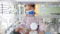 Seorang petugas medis tampak merawat bayi yang baru lahir di sebuah rumah sakit di Lianyungang, Tiongkok, pada 8 Maret 2023. (Foto: AFP)