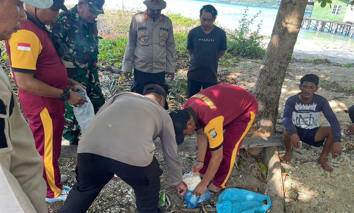 Kapolsek Jemaja beserta anggota menyaksikan penggalian paket benda mencurigakan yang ditanam warga usai ditemukan di pesisir Pulau Peneson Kecil. (Dok. Humas Polres Anambas)