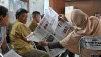 Petugas pemungutan suara dan saksi membaca berita saat penghitungan suara dalam pemilu legislatif di Jakarta, 12 April 2014. (Foto: Bay Ismyoyo/AFP)