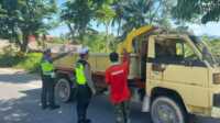 truk tanah di Karimun Dua personel Satlantas Polres Karimun menghentikan dan menegur supir truk yang mengangkut tanah tanpa ditutupi terpal di Jalan Poros, Kamis (25/5/2023). Truk tanah ini dikeluhkan wrga karena debunya beterbangan dan menutupi badan sehingga berlumpur saat hujan. (Dok. Humas Polres Karimun)