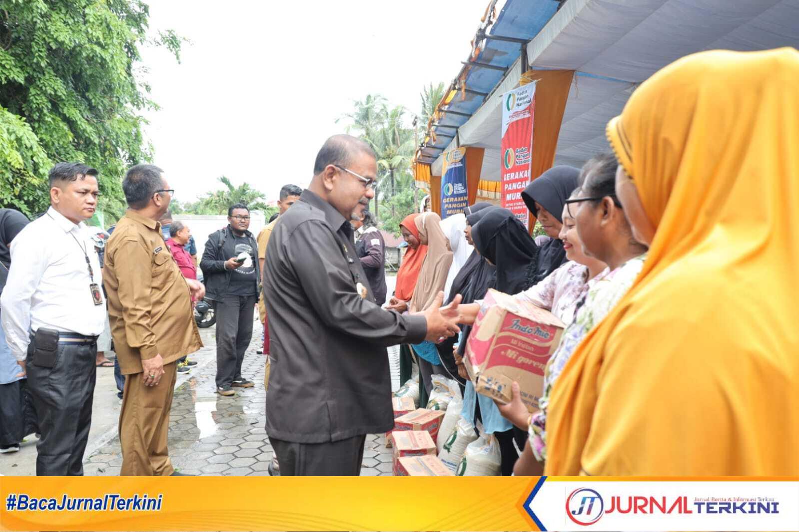 Bupati Karimun Aunur Rafiq memberikan bantuan kebutuhan pokok kepada sejumlah warga di sela pasar pangan murah di Kolong, Sungai Lakam Barat, Kecamatan Karimun, Senin (26/6/2023). (JurnalTerkini.id/Yogi)