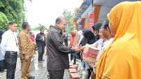 Bupati Karimun Aunur Rafiq memberikan bantuan kebutuhan pokok kepada sejumlah warga di sela pasar pangan murah di Kolong, Sungai Lakam Barat, Kecamatan Karimun, Senin (26/6/2023). (JurnalTerkini.id/Yogi)