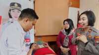 Wakapolres Karimun Kompol Petra C K Tumengkol menghibur salah satu anak yang dikhitan dalam kegiatan bulan bakti presisi Hari Bhayangkara ke-77 di Mapolsek Balai Karimun,, Rabu (14/6/2023). (JurnalTerkini.id/Janse)