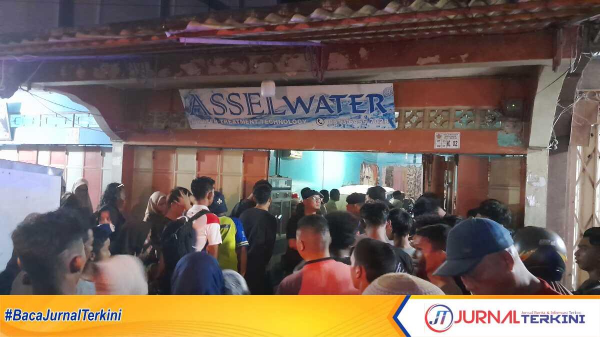 Warga berkerumun di depan depot air minum asselwater tempat ditemukannya jenazah Rinto, Sabtu (30/6/2023) malam. (JurnalTerkini.id/Jansen)