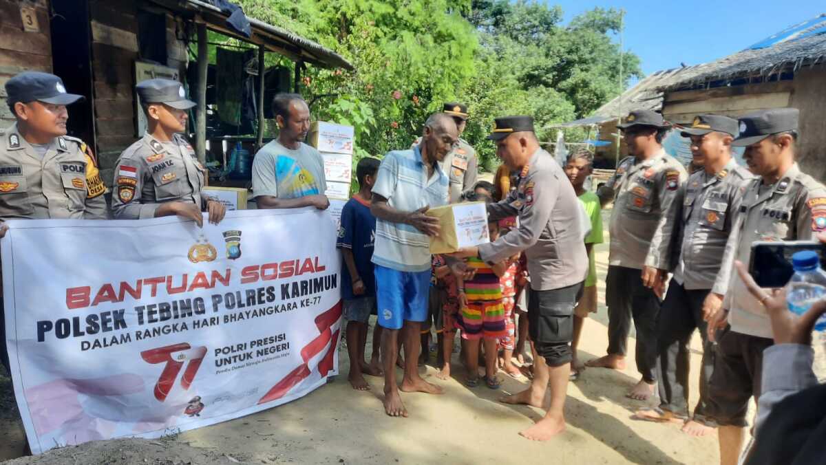 Kapolsek Tebing AKP M Djaiz bersama jajaran berfoto bersama warga suku asli di Pulau Karimun Anak dalam penyerahan bansos dalam rangka Hari Bhayangkara ke-77, Jumat (23/6/2023). (Dok. Humas Polres Karimun)
