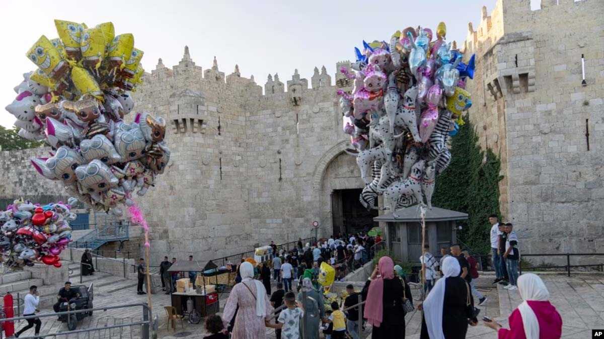 gerbang damaskus yerussalem Umat Islam berjalan melewati Gerbang Damaskus di luar Kota Tua Yerusalem untuk menunaikan shalat Idul Adha di kompleks Masjid Al Aqsa, Rabu, 28 Juni 2023. (AP/Ohad Zwigenberg)