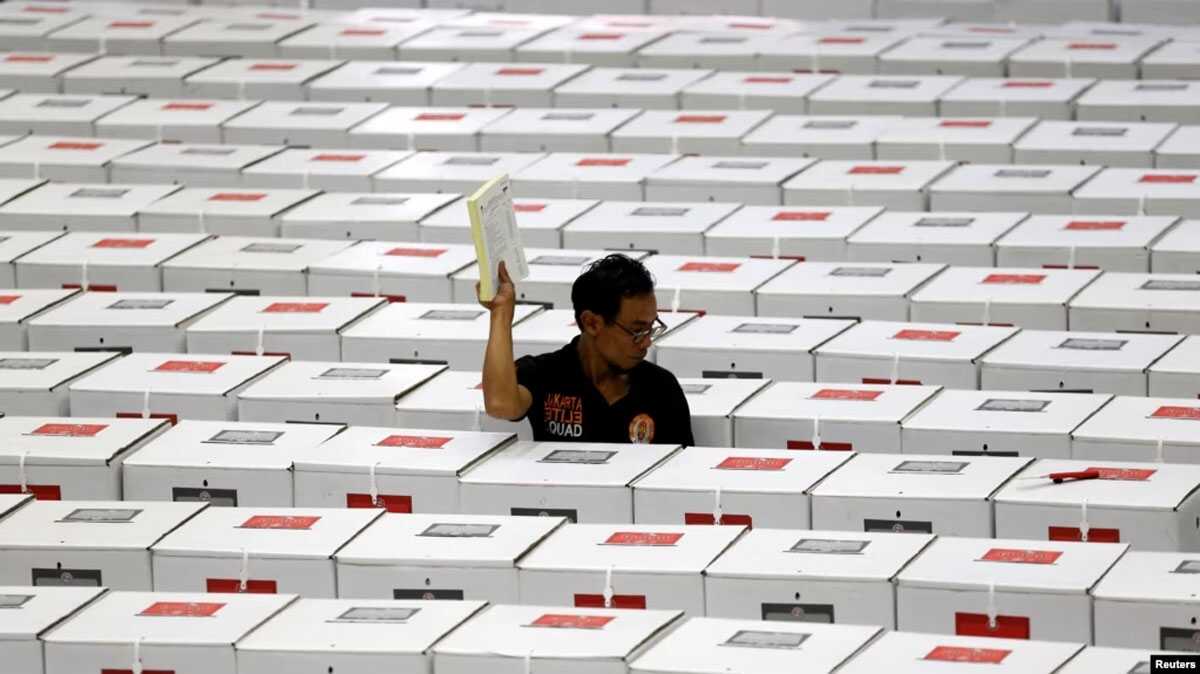 Seorang pekerja membawa bahan pemilihan saat menyiapkan kotak suara sebelum didistribusikan ke TPS di sebuah gudang di Jakarta, 15 April 2019. (Foto: REUTERS/Willy Kurniawan)