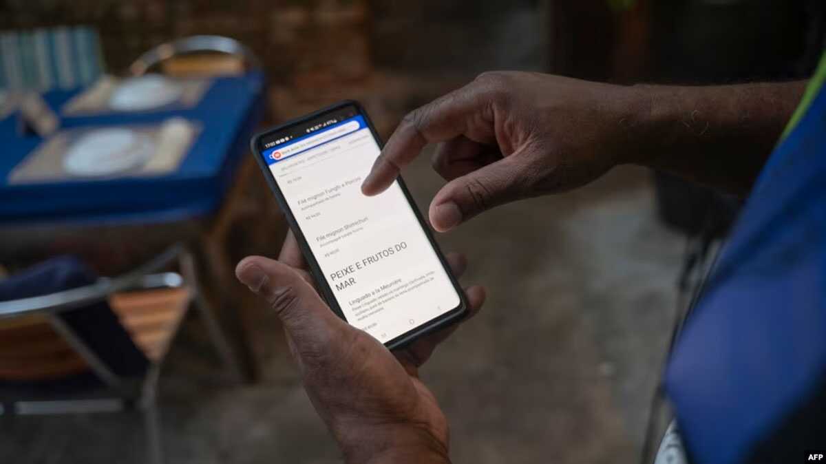qr code Seorang pekerja menunjukkan menu digital di restoran Casa Nossa di lingkungan Lapa di Rio de Janeiro, Brazil, 24 Mei 2023. (MAURO PIMENTEL/AFP)