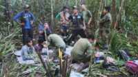 tersesat di amazon Sejumlah tentara dan penduduk pribumi merawat empat anak yang hilang setelah kecelakaan pesawat di hutan Solano, negara bagian Caqueta, Kolombia, Jumat, 9 Juni 2023. (Kantor Pers Angkatan Bersenjata Kolombia via AP via VOA)