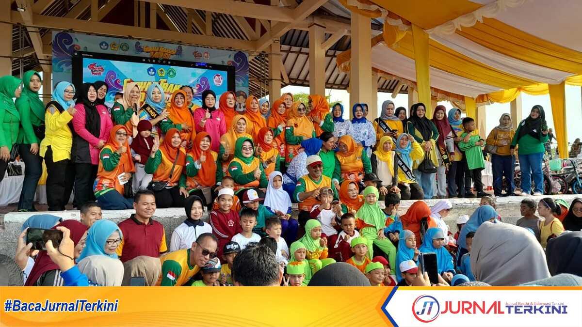 gebyar transisi PAUD-SD di Karimun-3 Bupati Karimun Aunur Rafiq (duduk di tangga atas) berpose bersama anak-anak yang sempat menyerbu panggung untuk mendapatkan hadiah dalam acara Gebyar Transisi PAUD-SD dalam rangka Hari Anak Nasional di lapangan Putri Kemuning, Coastal Area, Tanjung Balai Karimun, Minggu (23/7/2023). (JurnalTerkini.id/Rusdi)