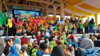 Bupati Karimun Aunur Rafiq (duduk di tangga atas) berpose bersama anak-anak yang sempat menyerbu panggung untuk mendapatkan hadiah dalam acara Gebyar Transisi PAUD-SD dalam rangka Hari Anak Nasional di lapangan Putri Kemuning, Coastal Area, Tanjung Balai Karimun, Minggu (23/7/2023). (JurnalTerkini.id/Rusdi)