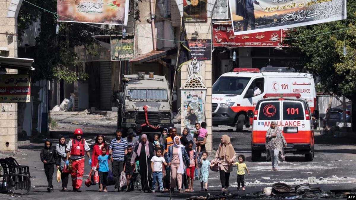 israel militan palestina Warga kamp pengungsi Jenin di Tepi Barat yang diduduki melarikan diri saat berlangsungnya operasi militer Israel, 4 Juli 2023. (RONALDO SCHEMIDT/AFP)