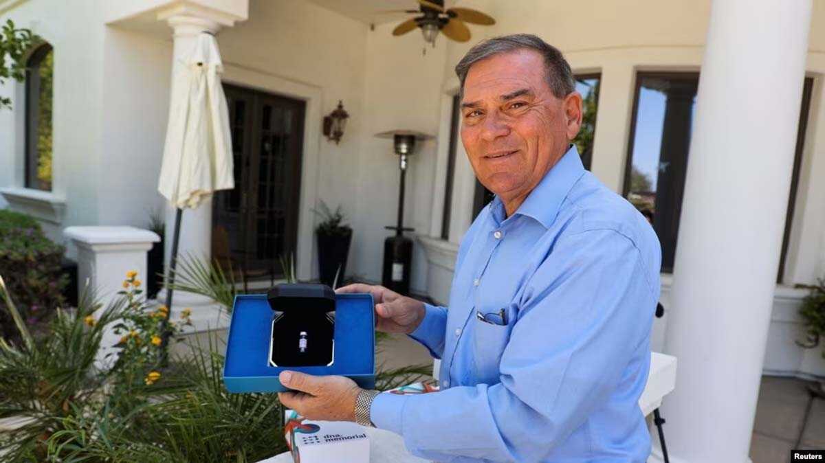 pemakaman di luar angkasa Gerry Paulus memegang DNA Memorial Kit yang diberikan kepada keluarga oleh Celestis, inc. sebagai kenang-kenangan bagi para pengguna jasa penguburan luar angkasa mereka, di Mesa, Arizona, AS, 26 Juni 2023. (REUTERS/Liliana Salgado)