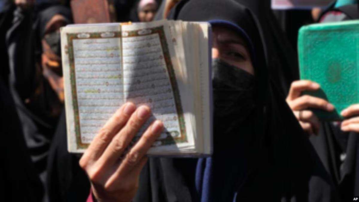 Seorang pengunjuk rasa mengangkat Al-Qur'an saat melakukan protes terkait pembakaran Al-Qur'an di Swedia, di depan Kedutaan Besar Swedia di Teheran, Iran, Jumat, 30 Juni 2023. (Foto: AP)