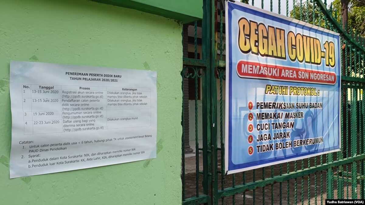 FILE - Tempelan kertas berisi jadwal Penerimaan Peserta Didik Baru (PPDB) untuk sekolah dasar negeri ditempel di pintu masuk salah satu SD Negeri di Solo, Minggu, 14 Juni 2020. (Foto: VOA/Yudha Satriawan)