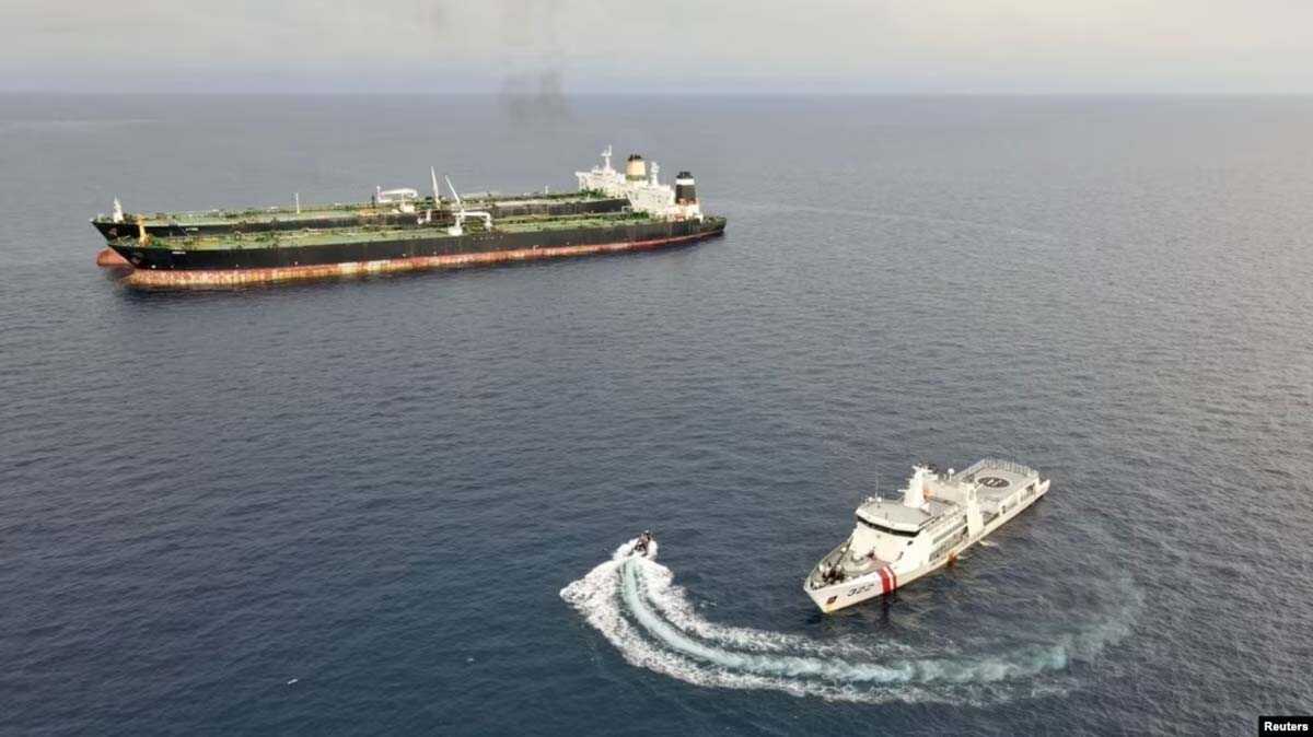 Kapal patroli KN. Pulau Marore-322 milik Bakamla menginspeksi kapal MT Arman 114 berbendera Iran, dan MT S Tinos berbendera Kamerun, saat terlihat melakukan pelayaran kapal- transfer minyak ke kapal tanpa izin, dekat Laut Natuna Utara, 7 Juli 2023 (Bakamla/ Handout via REUTERS)