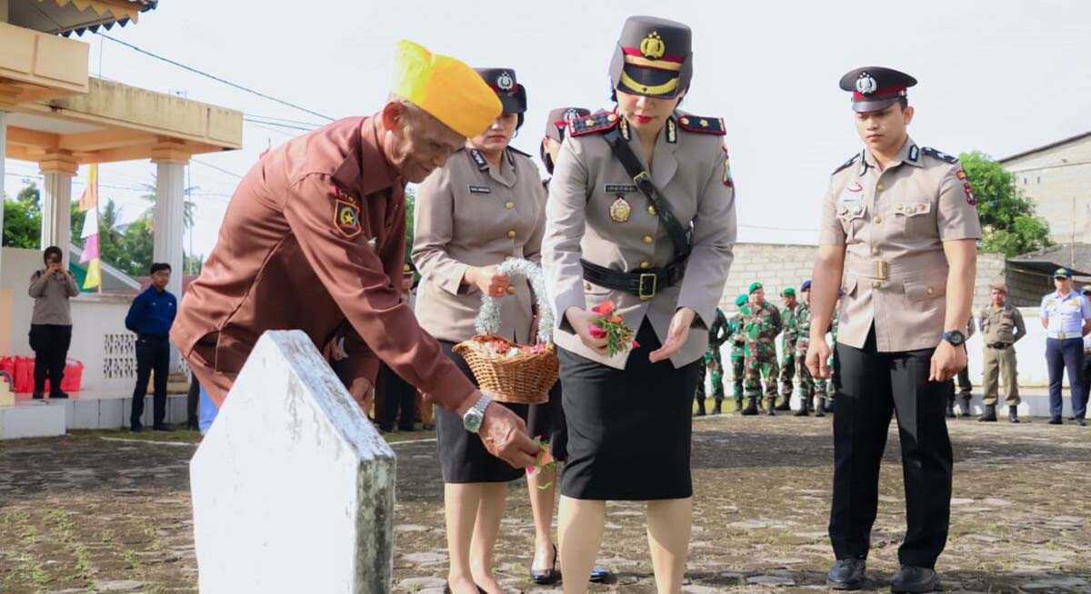 Wakapolres Karimun Kompol Petra. C. K. Tumengkol bersama seorang veteran menabur bunga saat ziarah makam pahlawan di Tanjungbaru, Kecamatan Kundur, Selasa (27/6/2023). (Dok. Humas Polres Karimun)