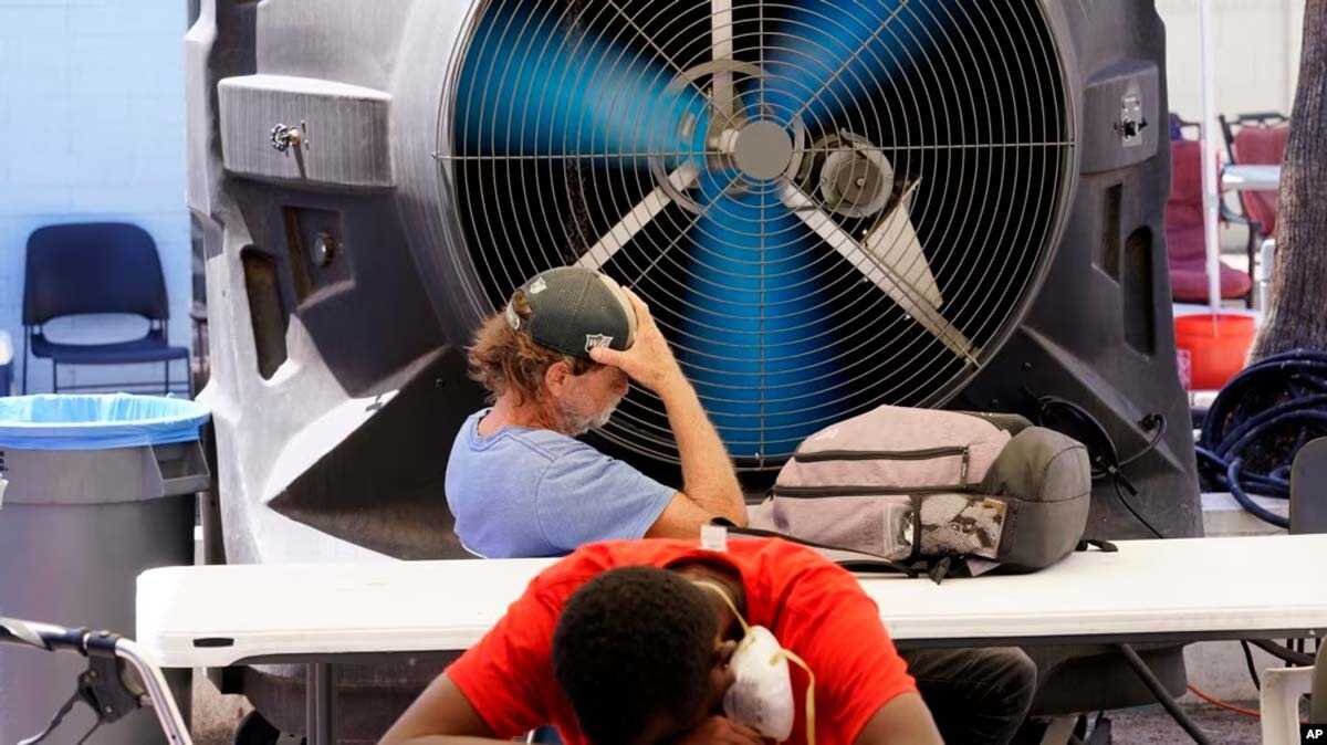 Bulan terpanas di bumi Dua pria tunawisma mendinginkan diri di Justa Center, layanan khusus bagi warga tunawisma, saat suhu mencapai 110 derajat (di atas 43 Celsius) di Phoenix, Arizona (foto: dok VOA).